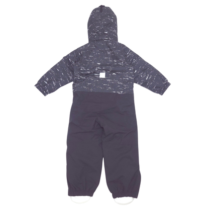 A hooded one-piece snowsuit or jumpsuit in dark charcoal gray with a white speckled pattern across the upper body and sleeves, and solid dark gray lower legs, shown flat against a white background.