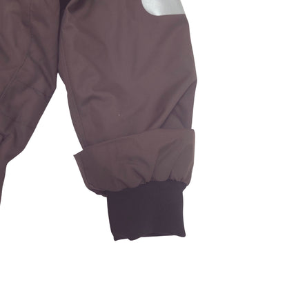 Close-up of a dark brown suit sleeve with a black ribbed cuff