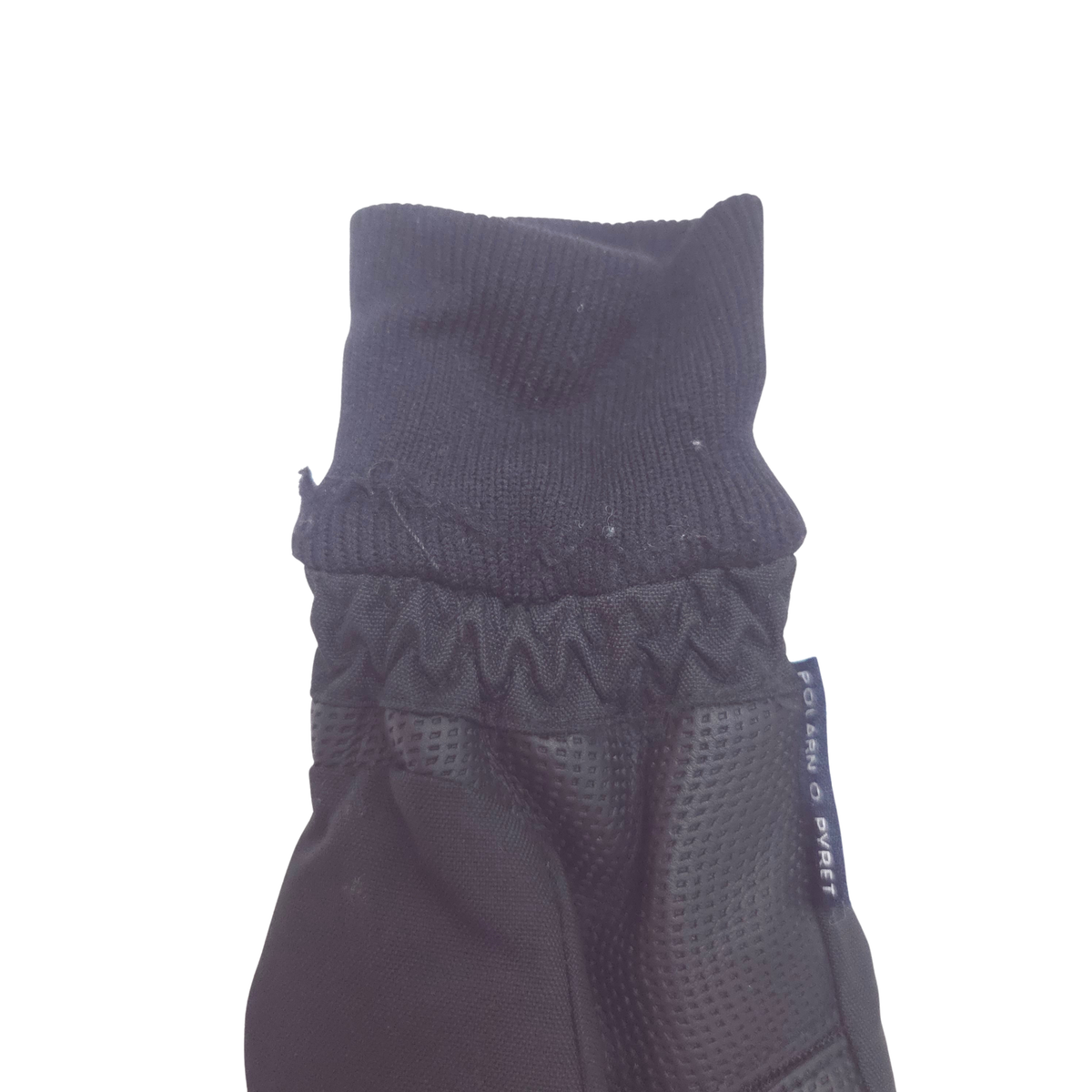Close-up of a black knit and mesh winter glove cuff with a visible brand tag reading 'POLARN O PYRET'.