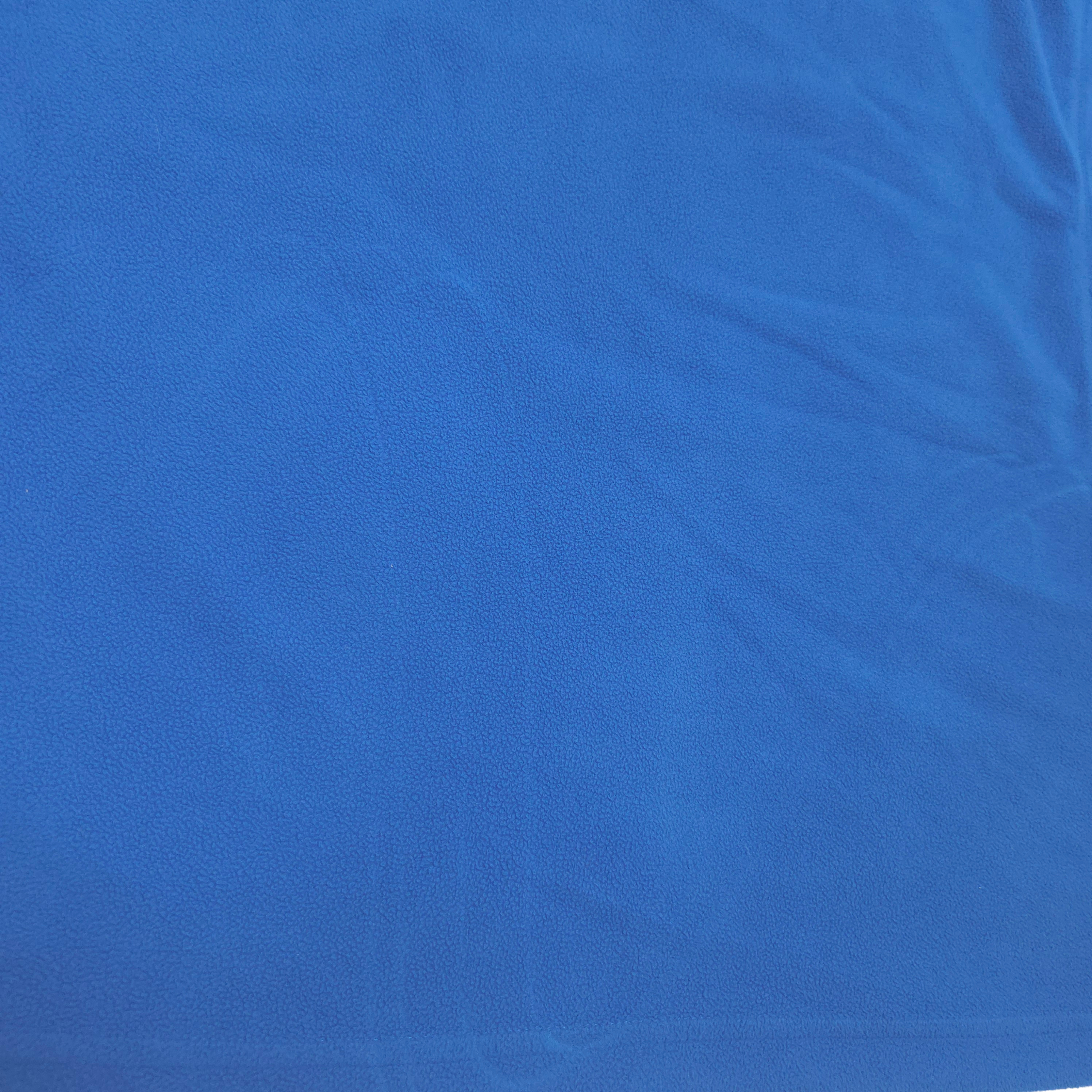 A close-up of a vibrant blue textured fabric with soft folds and creases.