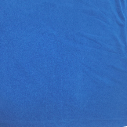 A close-up of a vibrant blue textured fabric with soft folds and creases.