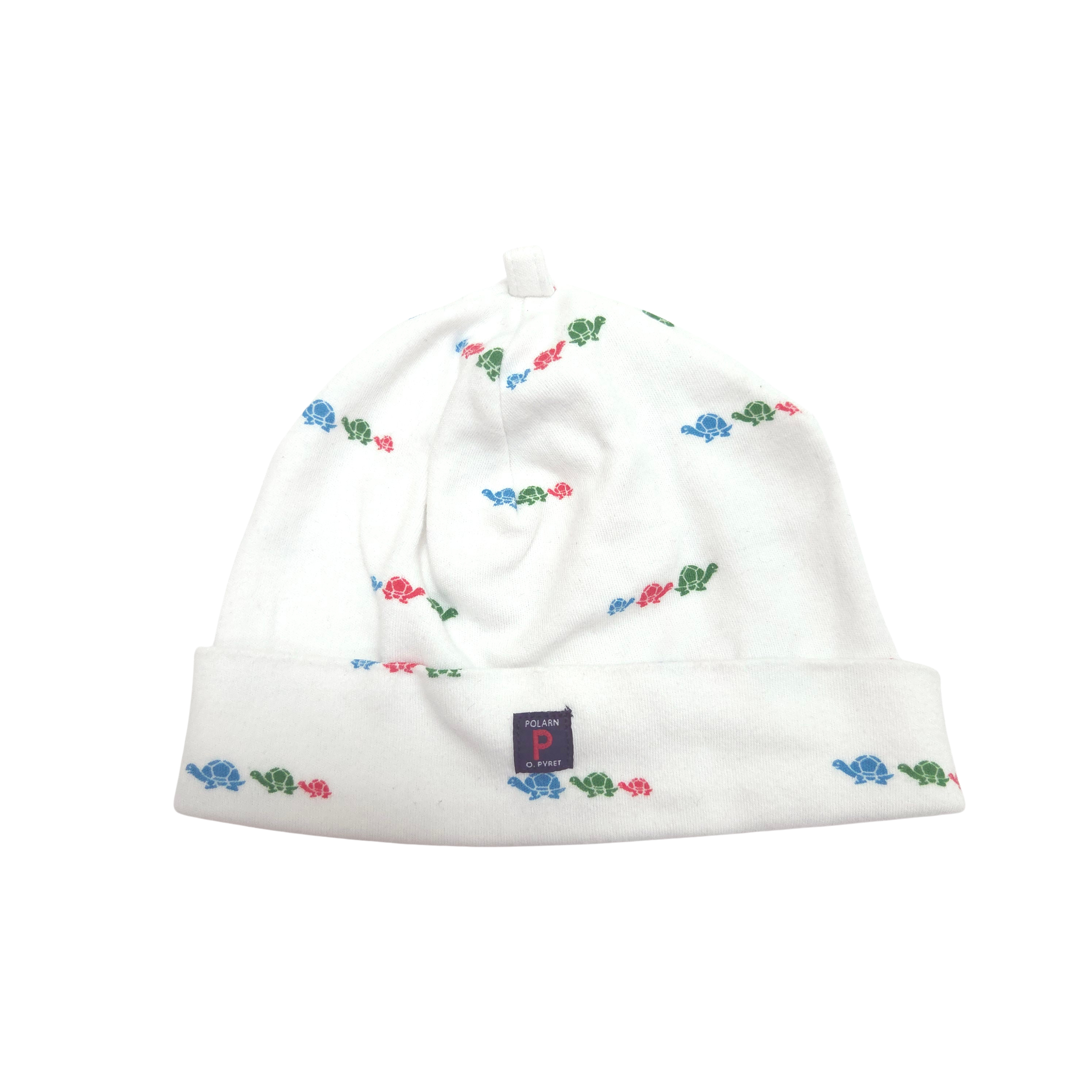 A white knit baby beanie hat with a small repeating pattern of colorful turtles in blue, red, and green, featuring a folded cuff and a small navy brand tag.