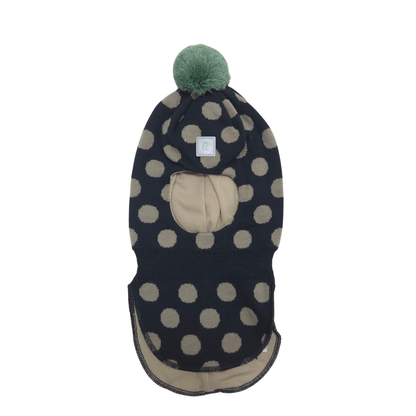 A knit balaclava with a black and beige polka dot pattern, featuring a beige face opening, a beige inner lining, and a green pom-pom on top.
