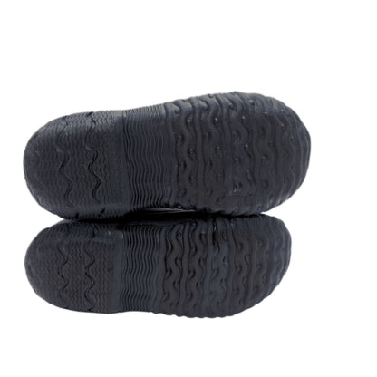 A pair of black rubber shoe soles with deep, textured tread patterns, shown from the bottom against a plain white background.