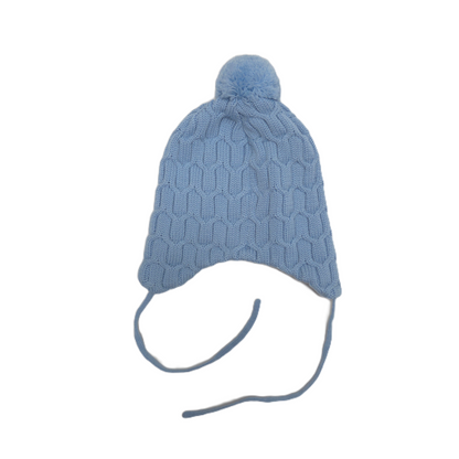 A light blue cable-knit beanie hat with a matching pom-pom on top and ear flaps with tie strings, shown against a plain white background.