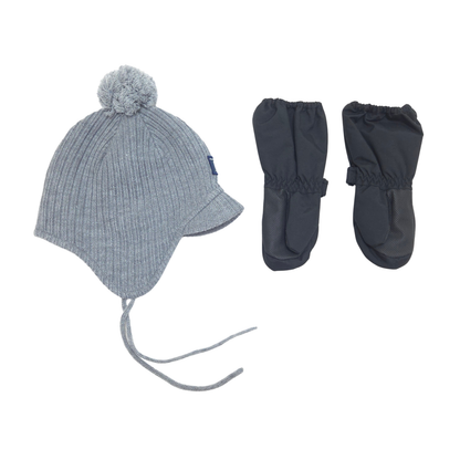 A baby winter hat set on a white background, featuring a light gray ribbed knit pom-pom hat with ear flaps and ties, alongside a pair of black winter mittens.
