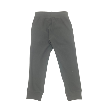 A pair of black sweatpants with an elastic waistband and ribbed ankle cuffs, shown flat against a plain white background.