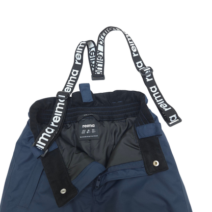 Close-up of navy blue Reima snow pants with black adjustable suspenders featuring white Reima branding, shown on a white background.