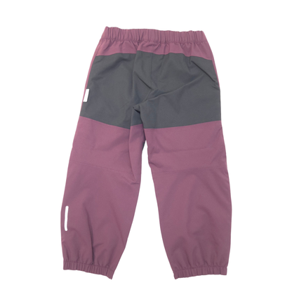 A pair of color-blocked children's pants in dusty purple and black, shown from the back on a white background.