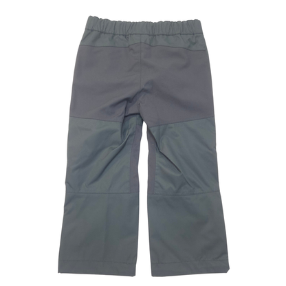 A pair of black color block pants laid flat against a white background.