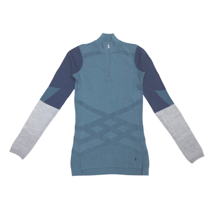 A women's long-sleeve quarter-zip wool athletic top in a color-blocked design, featuring a slate blue body, navy blue shoulders, and light gray sleeves, shown flat on a white background.