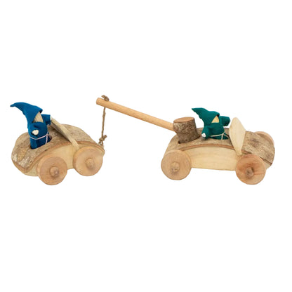 Handcrafted wooden toy cars with gnome figures, shown on a clean white background. One small wooden car with a blue gnome pulls another wooden car with a green gnome.