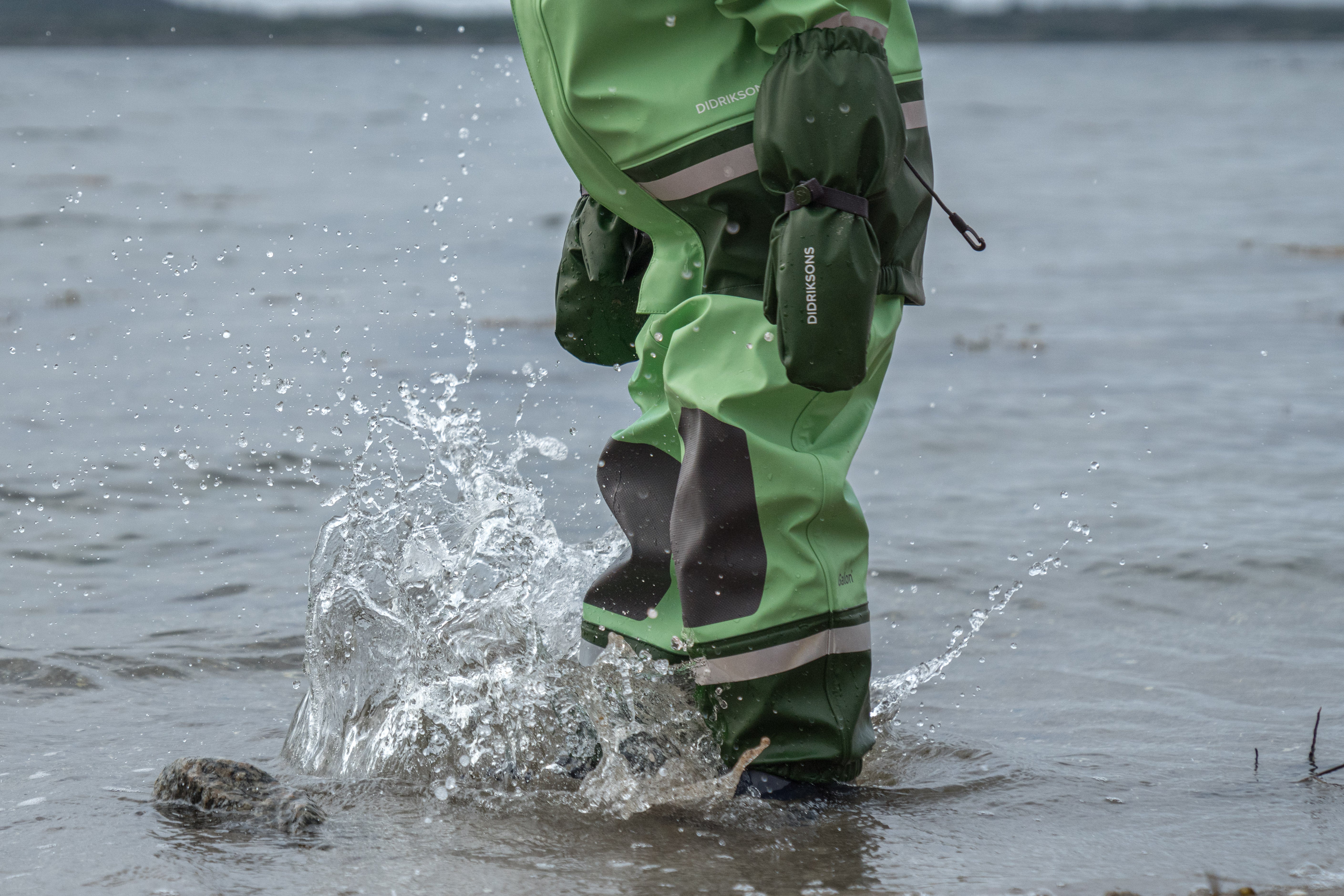 Person wearing green waders walking through water