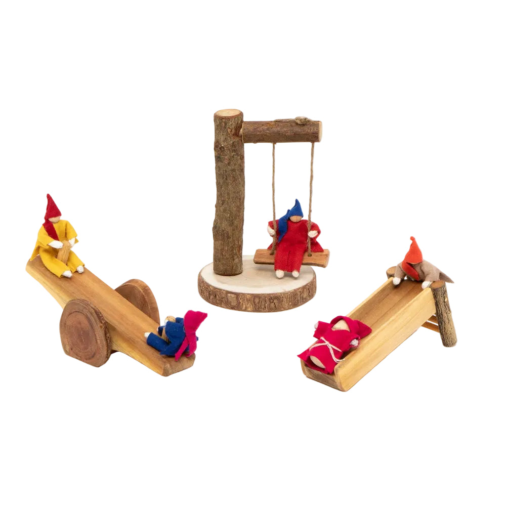 A miniature wooden children's playset featuring a seesaw with two small gnome figures, a swing set with one gnome, and a slide with another gnome, all crafted from natural wood on a white background.