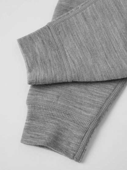 Close-up of folded gray ribbed knit merino wool fabric, the leg cuffs of the romper style, on a light gray background. 