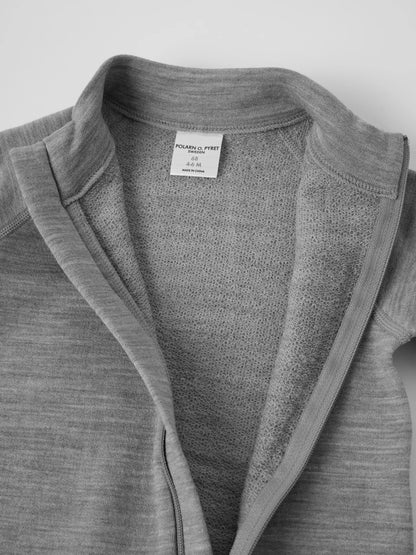 Close-up of a gray knit zip-front merino wool romper with a high ribbed collar and a white interior neck label. 