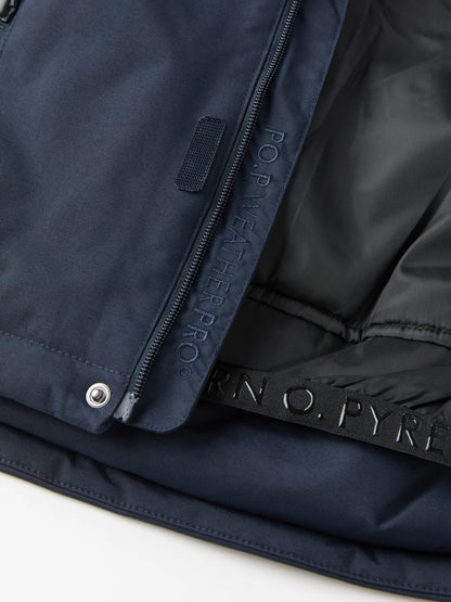 Close-up of a navy blue waterproof Polarn O. Pyret winter  jacket showing the exterior fabric, a zipper with 'FOR WEATHER PRO' text, and a view of the jacket's built in snow skirt. 