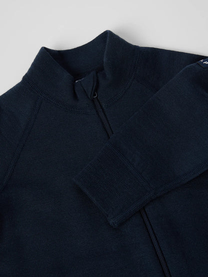 Close-up of a dark navy blue quarter-zip pullover sweater, showing the collar, zipper, and ribbed sleeve cuff against a light gray background. 